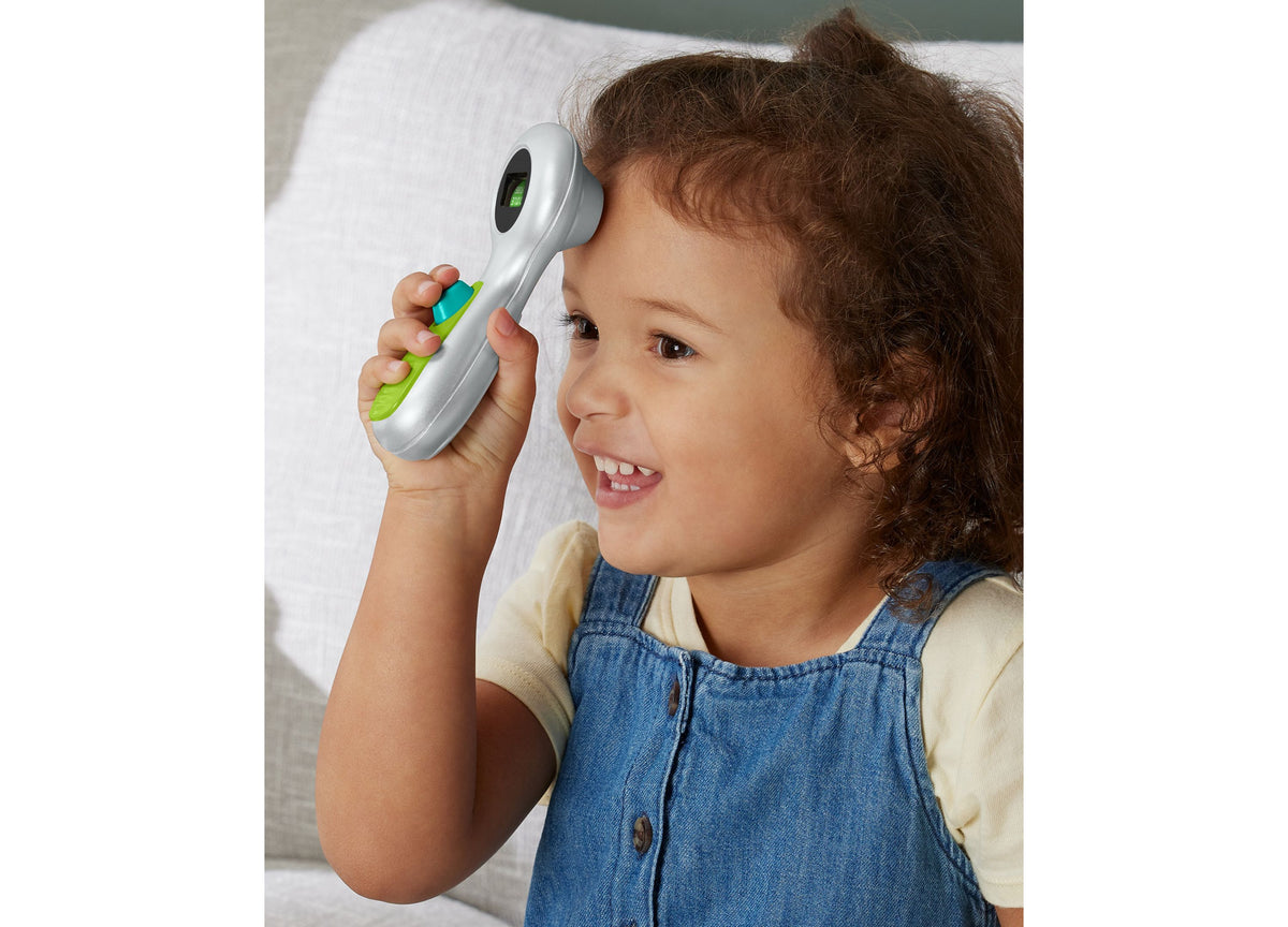 Child holding Fisher-Price Doctor Role Play Medical Kit stethoscope to ear during pretend checkup play