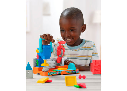 Boy playing with Play-Doh Stamp N Saw Tool Bench set featuring blue, red, orange, and yellow components