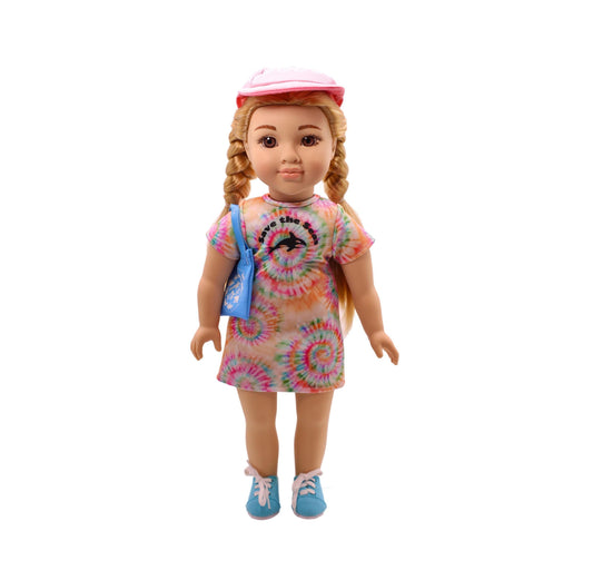 Doll with blonde braided hair wearing pink hat, tie-dye spiral dress with graphic print, blue shoulder bag, and blue sneakers