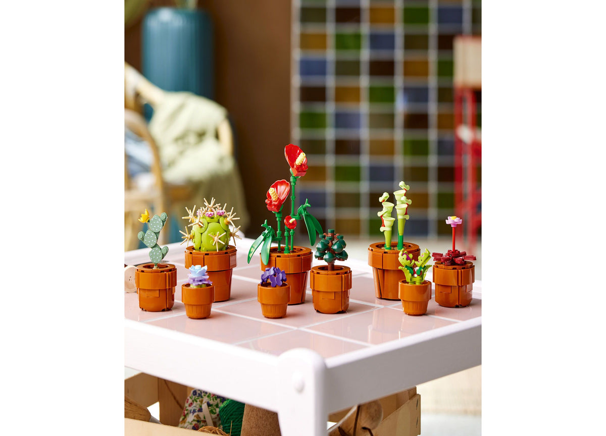 LEGO Icons Tiny Plants 10329 set with 9 colorful miniature plants in terracotta pots displayed on grid surface