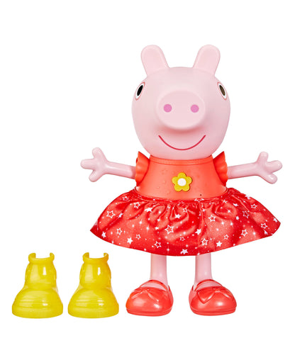 Pink Peppa Pig doll with smiling face, wearing red dress with white stars and yellow flower detail, red shoes, arms outstretched, with two yellow shoe accessori