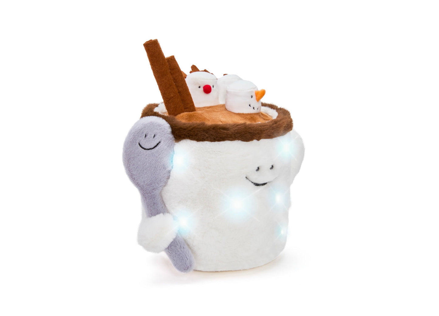 White plush hot chocolate mug with LED light-up features, smiling face, and brown rim topped with two small character plush toys and a cinnamon stick, with gray