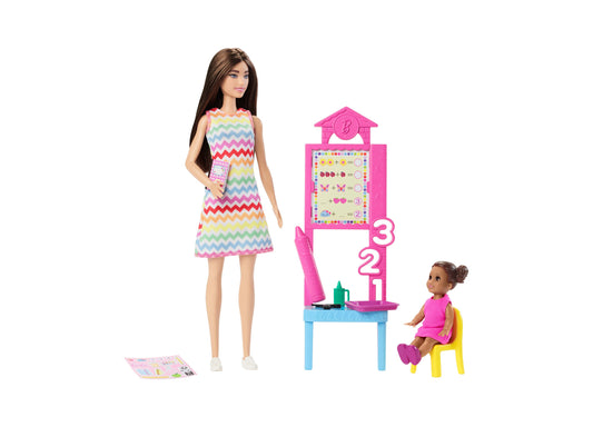 Barbie doll with long brown hair wearing colorful chevron dress, holding tablet, with classroom playset including pink teacher's desk, math board, small student