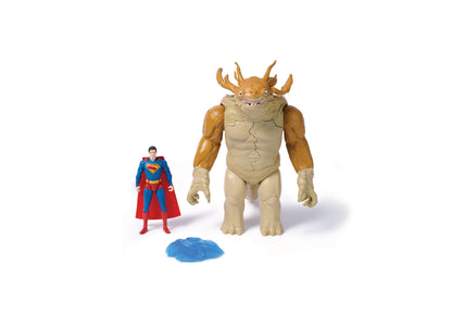 Superman action figure in blue and red costume standing next to large tan monster figure with brown horns and blue slime accessory on white background