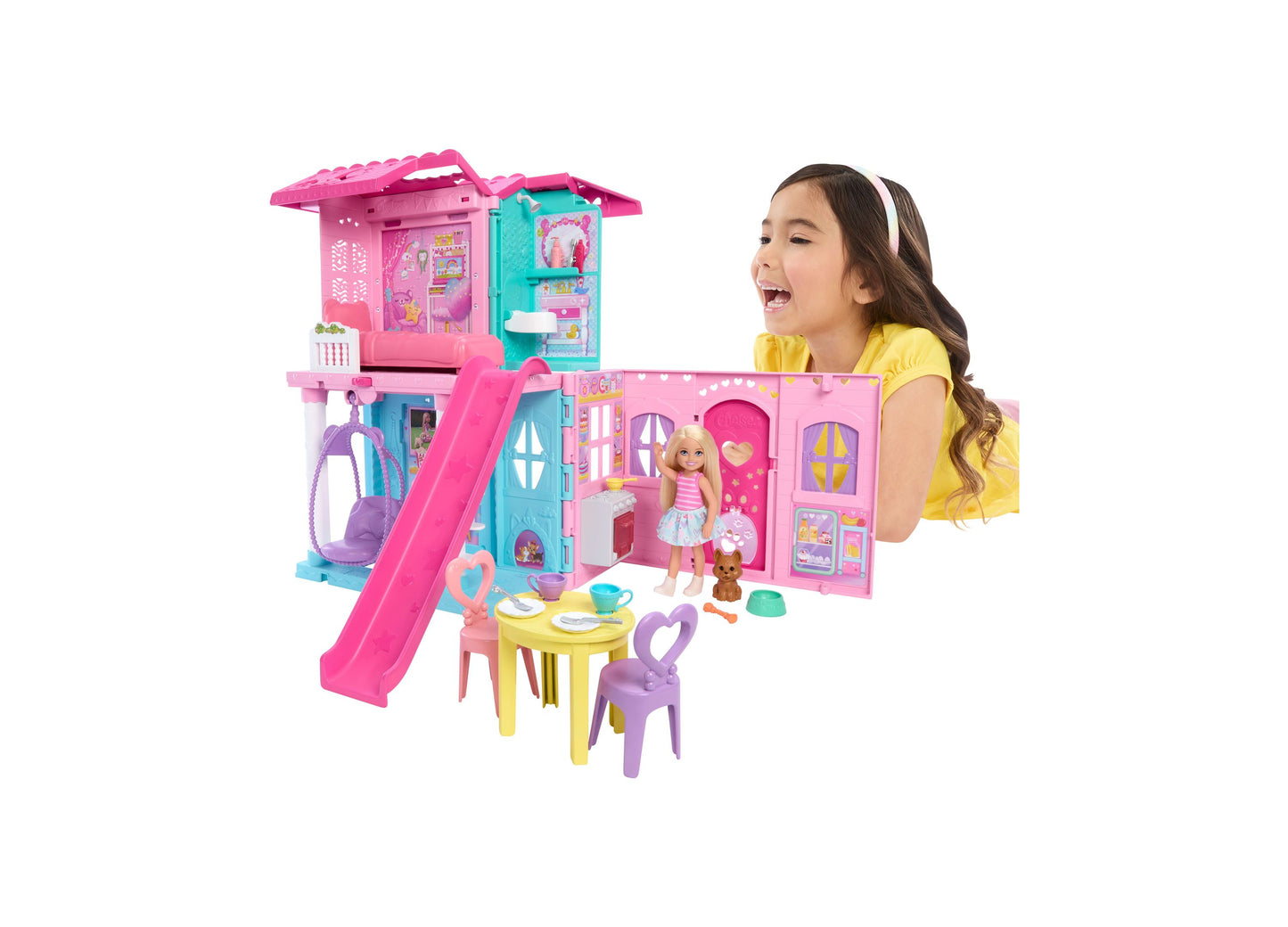 Barbie Chelsea Pop-Up Doll House with blonde doll, pink and turquoise playhouse featuring slide, furniture, and accessories, modeled by a child in yellow shirt