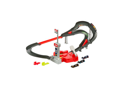 Hot Wheels racing track set with red and black loop-de-loop sections, gray tower with checkered flag, three die-cast race cars, and two plastic launcher pieces