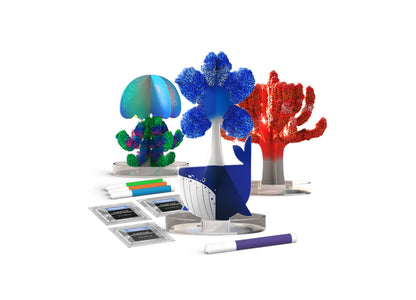 Sea Creations Chemistry Kit with blue, green, and red crystalline coral structures, colorful markers, instruction cards, and a blue whale figurine on white back