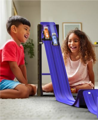 Geoffrey's Toy Box Downhill Derby Racetrack Set with blue track pieces, two children racing cars down the purple ramp