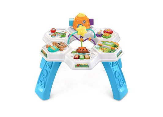 VTech Buzz & Learn Interactive Activity Table with blue legs, white hexagonal play stations featuring animals, buttons, and games, orange center tower with yell