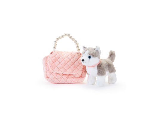 Gray and white plush husky with blue eyes next to pink quilted purse with pearl beaded handles