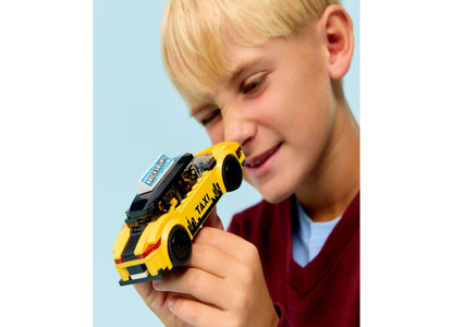 Child playing with LEGO City Yellow Taxi Car Building Toy 60487, featuring bright yellow and black colors