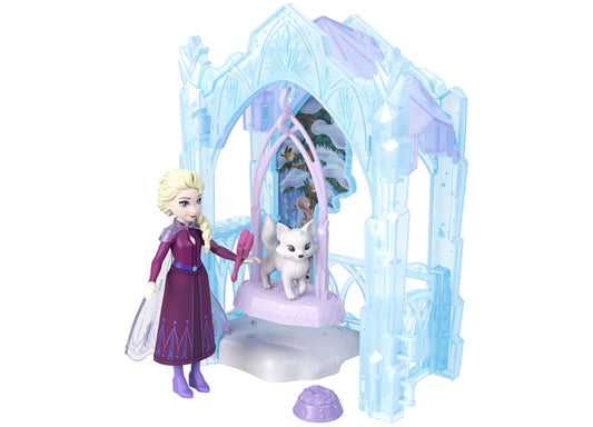 Disney Frozen Elsa doll in purple dress with blonde braid standing beside icy palace playset featuring white cat figure and pink interior details