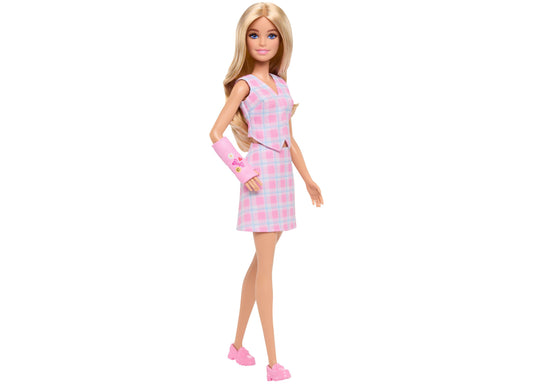 Barbie doll with blonde hair wearing pink and white plaid sleeveless dress with matching arm cast and pink shoes