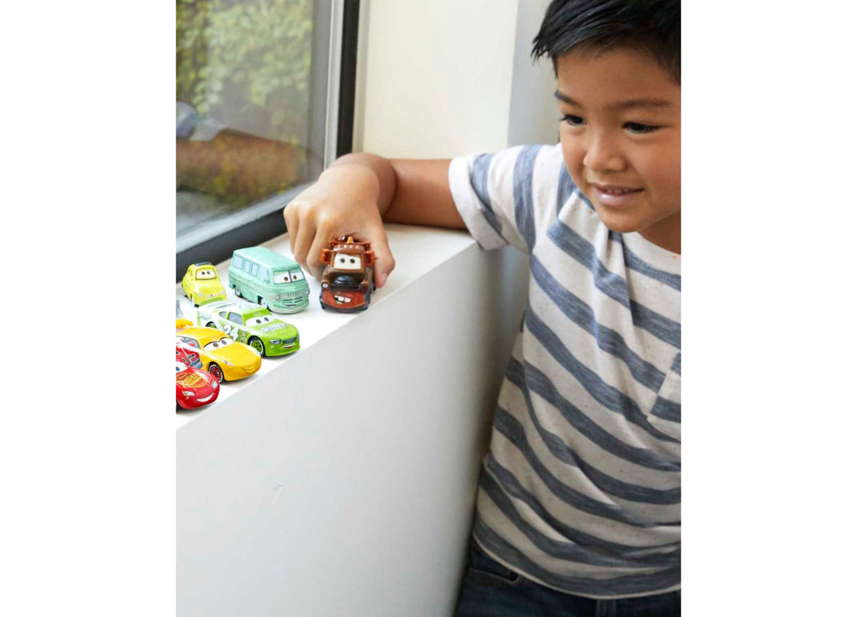 Child playing with Disney Pixar Cars Mini Racers Die-Cast Vehicle 10-Pack, featuring colorful miniature car character...