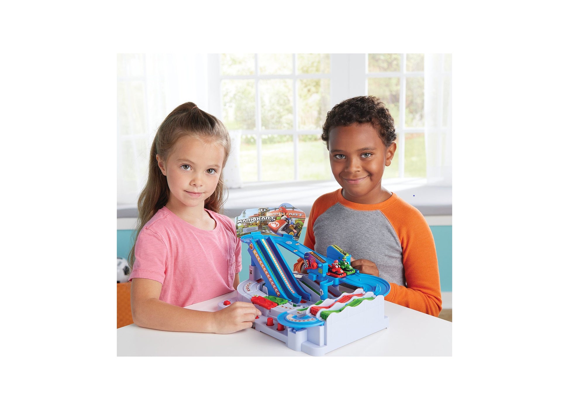 Two children playing with Super Mario Kart Racing Obstacle Course Track set on white table