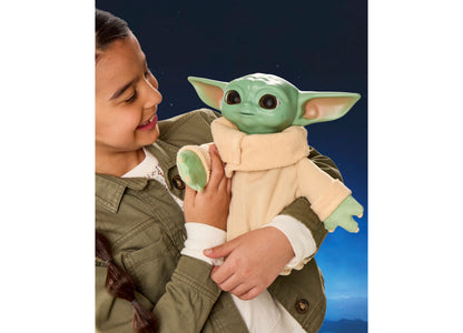 Star Wars Action Buddy Grogu plush toy with green skin and tan robe held by child