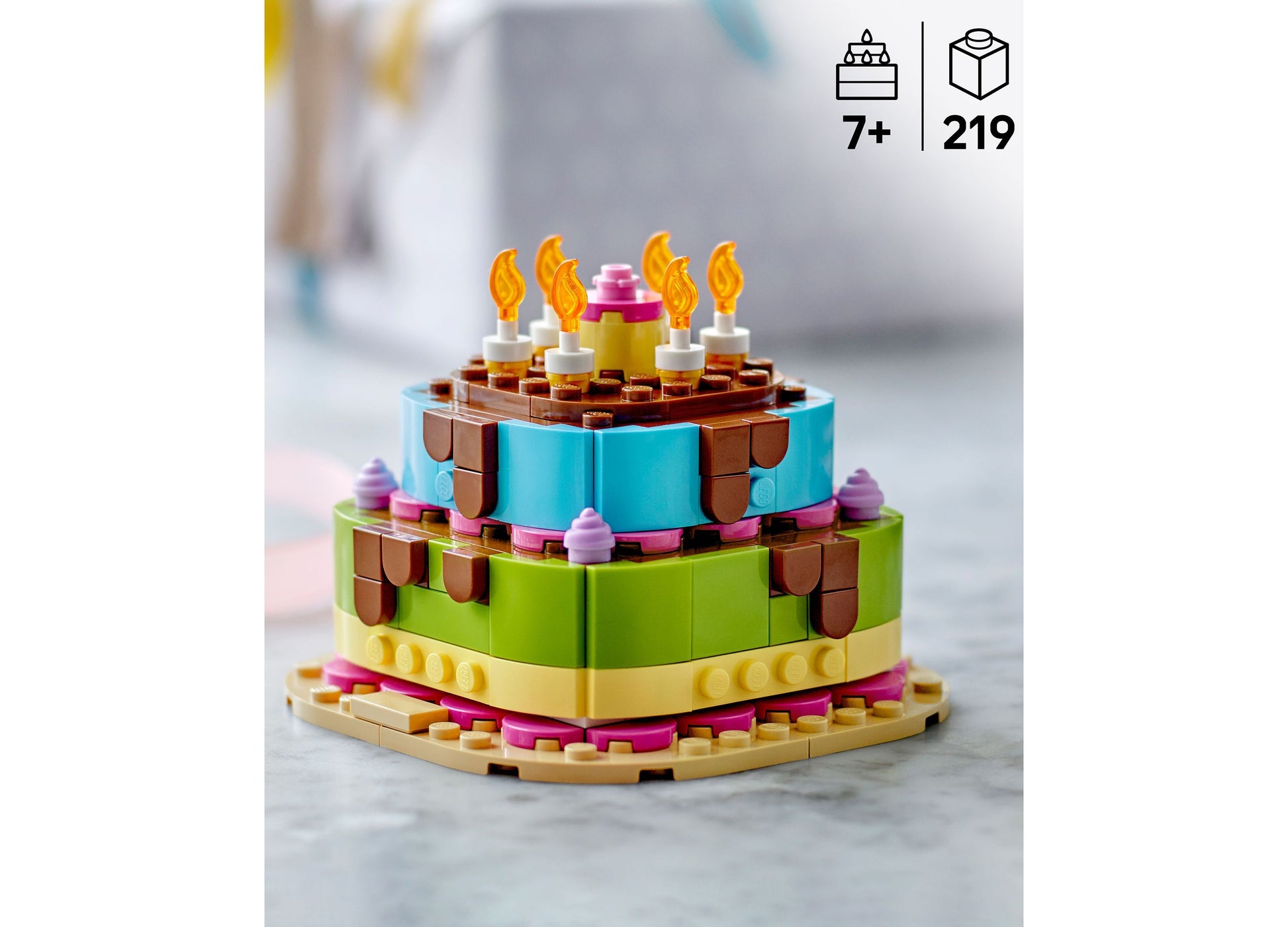 LEGO Birthday Party Cake Building Set 40815 with colorful blue, green, and yellow tiers, brown frosting details, and ...