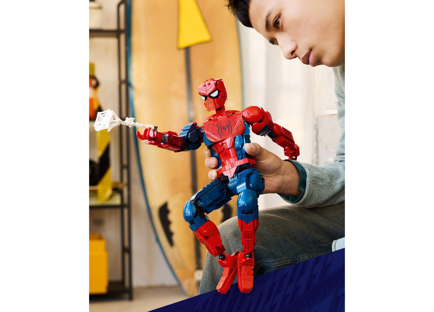 Child playing with LEGO Marvel Spider-Man Hero Figure 76346, red and blue buildable action figure with web accessory