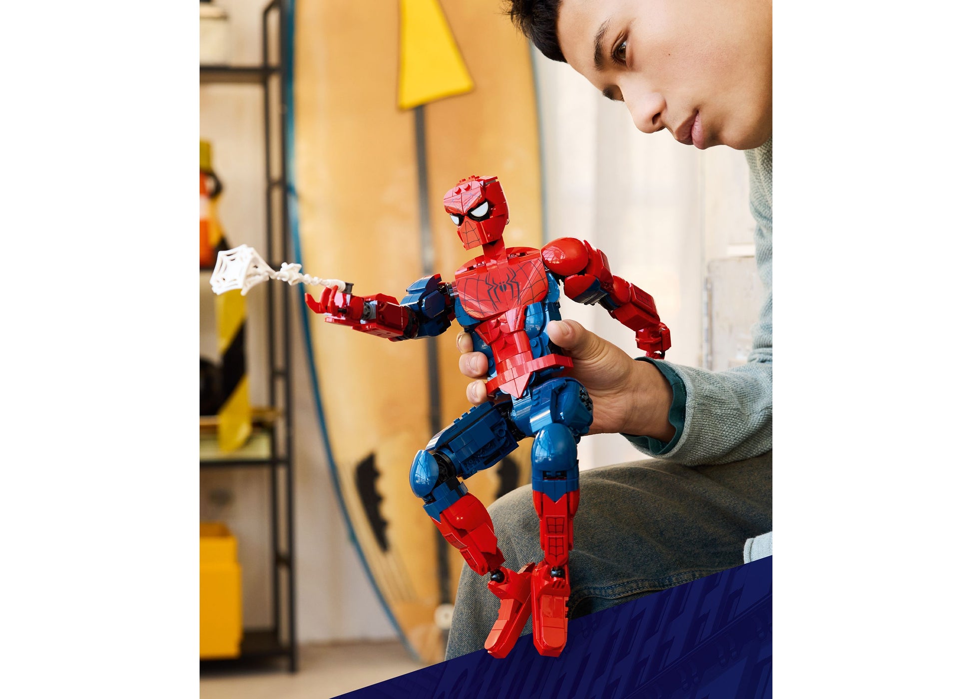 Child playing with LEGO Marvel Spider-Man Hero Figure 76346, red and blue buildable action figure with web accessory