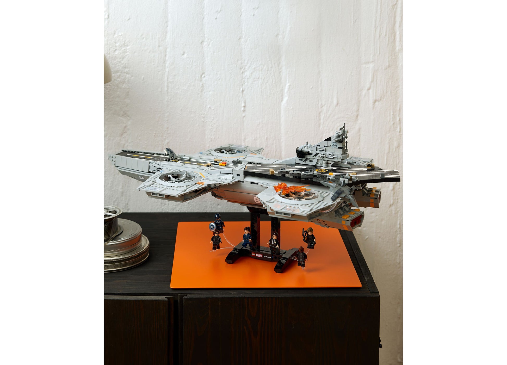 LEGO Marvel S.H.I.E.L.D. Helicarrier 76354 set with gray aircraft carrier, minifigures, and orange display base