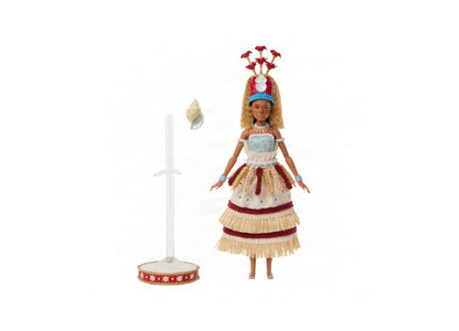 Moana doll in ceremonial dress with layered straw skirt, feathered headpiece with red flowers, shell necklace, and accessories including a stand and shell ornam