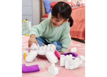 Child playing with Mega Bloks Build & Enchant Unicorn 26-Piece Building Set, white and purple chunky blocks arranged ...