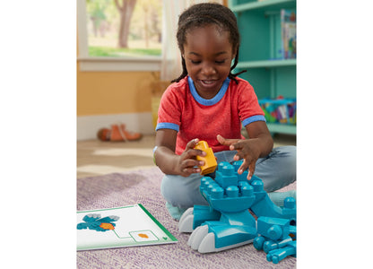 Mega Bloks Fisher-Price Build & Chomp Dinosaur set with blue and yellow blocks forming a T-Rex with open mouth, child...
