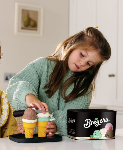 Casdon Breyers Ice Cream Scoop-and-Serve playset with child holding colorful cone scoops and black tub