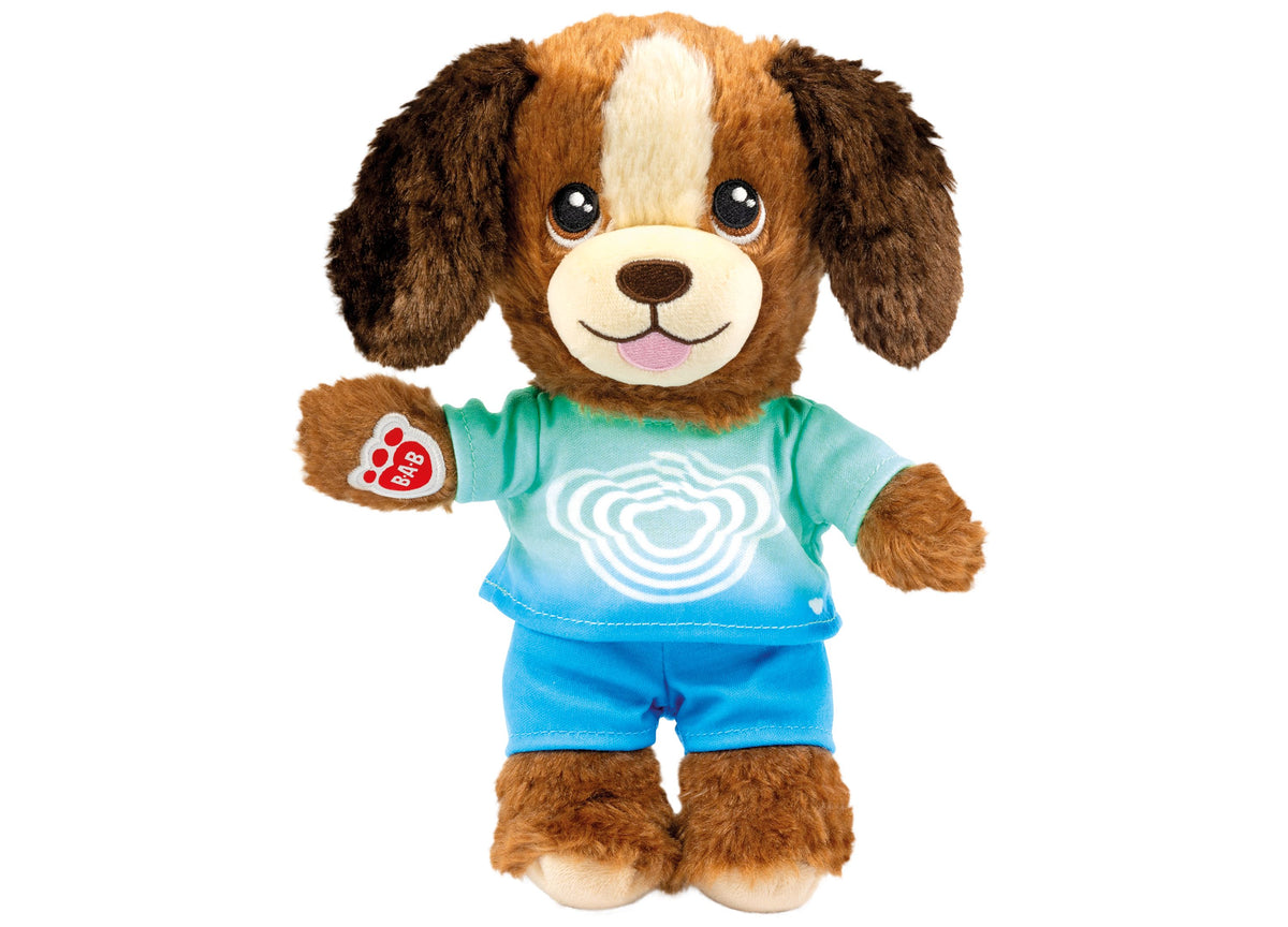 Brown and white puppy toy wearing turquoise shirt and blue shorts with heart design
