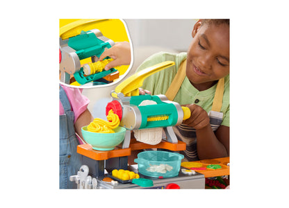 Play-Doh Super Sizzlin' Kitchen Playset with pasta maker in teal, yellow, and orange, child using pasta maker tool