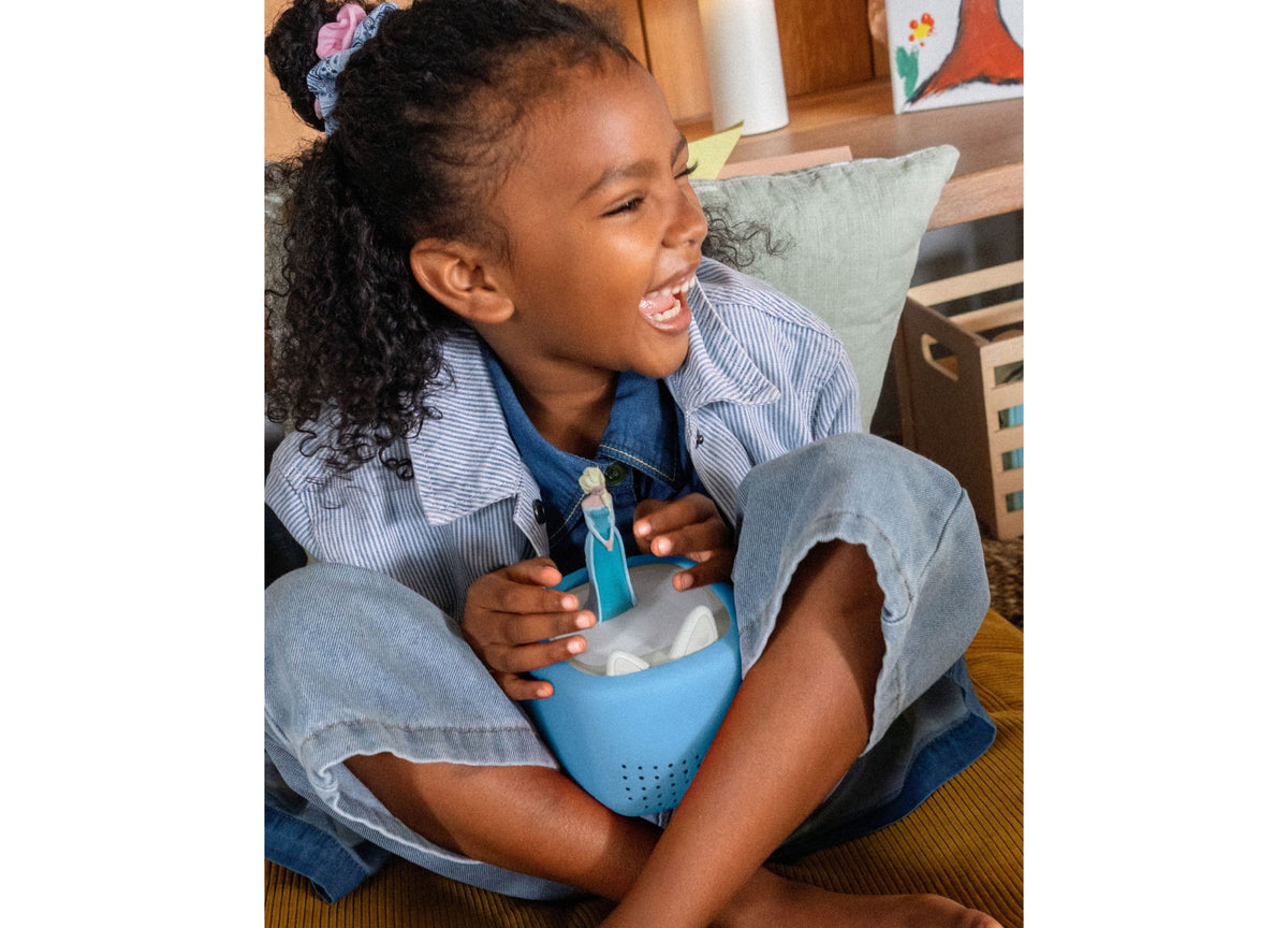 Child holding blue Tonies Toniebox Lite cover with cat-head design and speaker holes