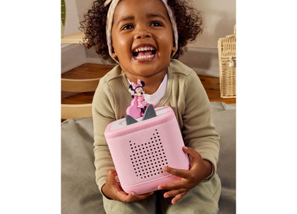 Tonies Minnie Mouse Clubhouse pink Tonie figurine with speaker grille, displayed by smiling child