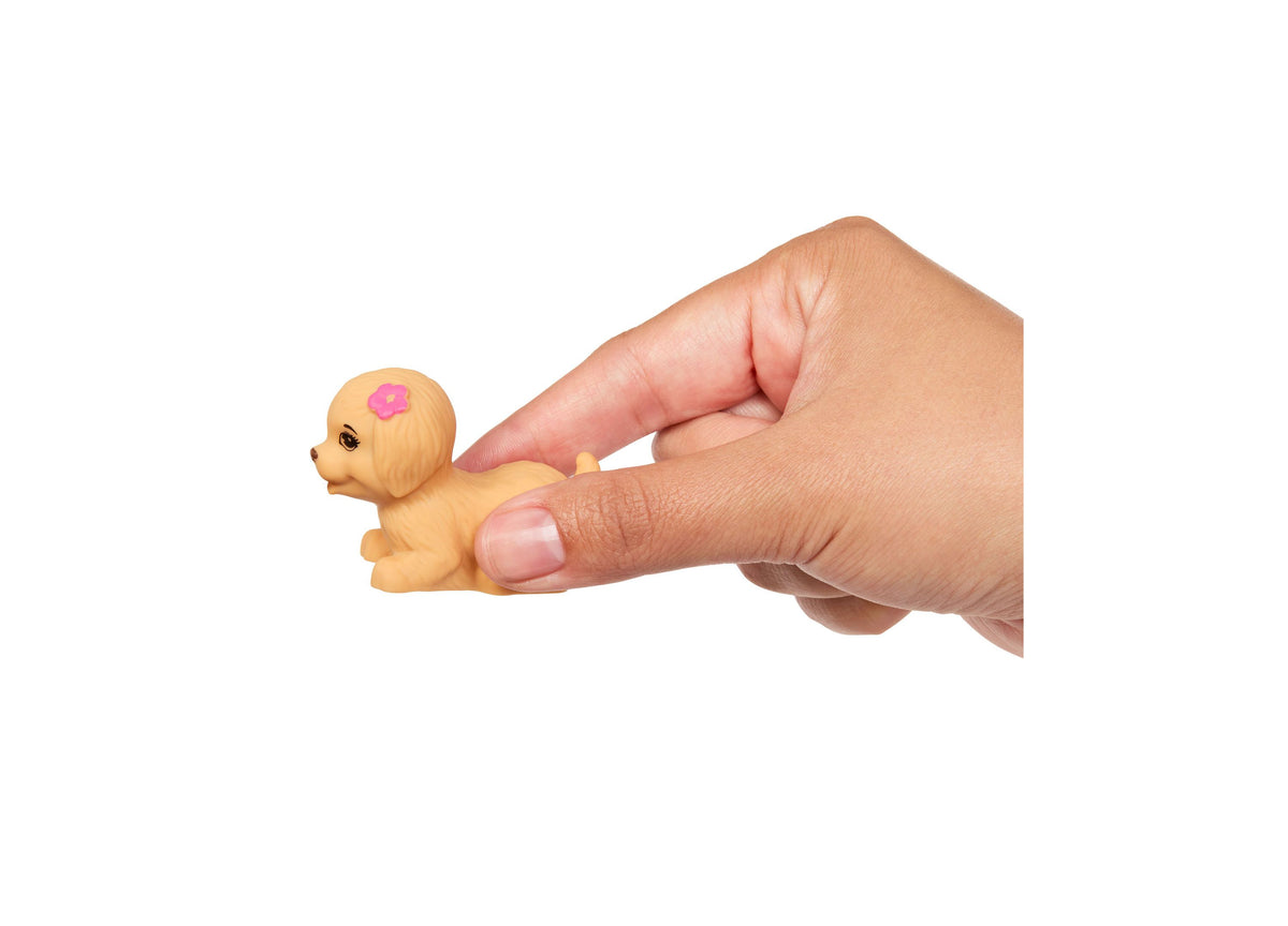 Small tan doll with pink flower marking held in hand, part of Barbie Chelsea pool party playset