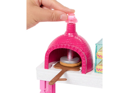 Barbie Pizza Shop playset with bright pink pizza oven, white counter, and brown pizza peel with dough