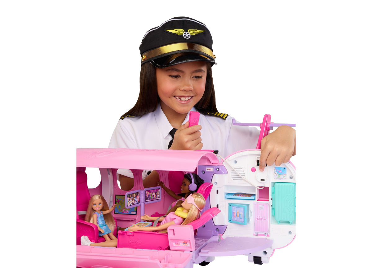 Barbie Dream Plane 15-piece airplane playset in pink and white with child in pilot costume playing with included doll...