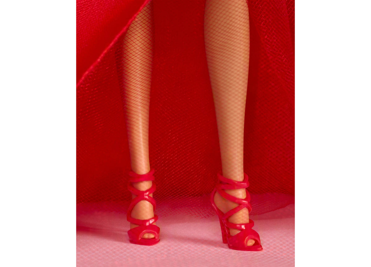 Barbie 2026 Holiday Doll wearing red gown with bow detail and fishnet stockings, red heeled shoes
