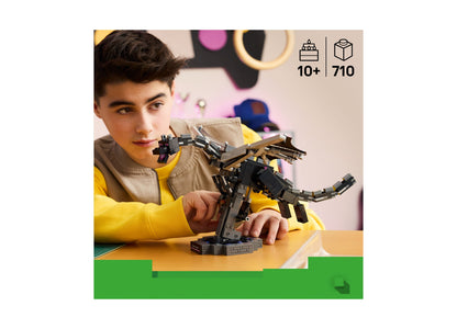 Boy playing with LEGO Minecraft Ender Dragon 21595 building set with black and gray pieces