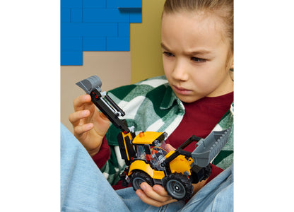 Child playing with LEGO City Backhoe Loader 60480 yellow and black construction vehicle toy