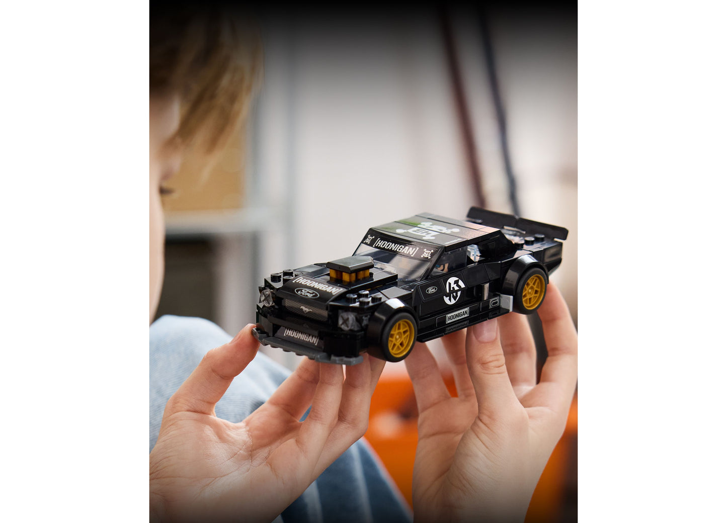 LEGO Ken Block's '65 Ford Mustang Hoonicorn V1 black and gold toy car held in hands