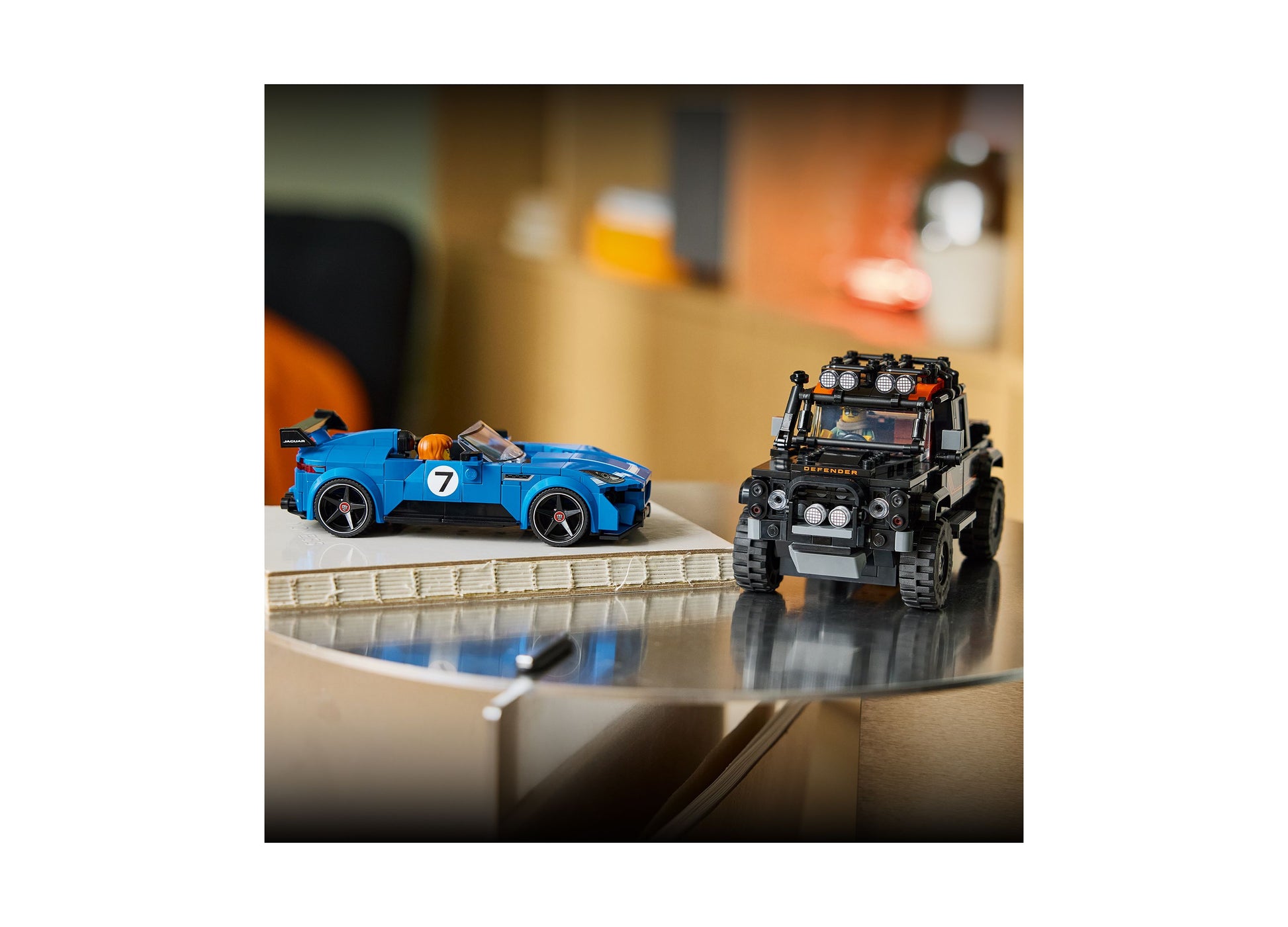 LEGO Jaguar Project 7 and Land Rover Defender building sets displayed together, blue sports car and black off-road ve...