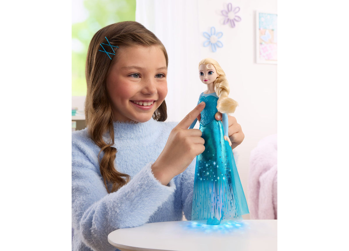 Girl holding Disney Princess Singing Elsa 11-inch light-up fashion doll in blue cape dress
