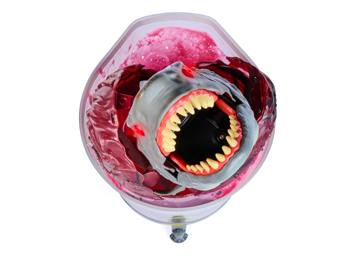 Primal Hatch Megalodon toy with light-up mouth, pink egg case, and yellow teeth