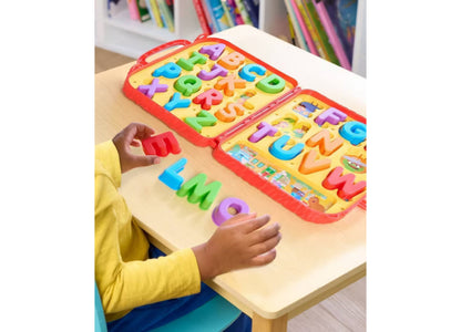 Child in yellow shirt playing with Sesame Street Letters activity set, arranging colorful ABC letters on yellow board...