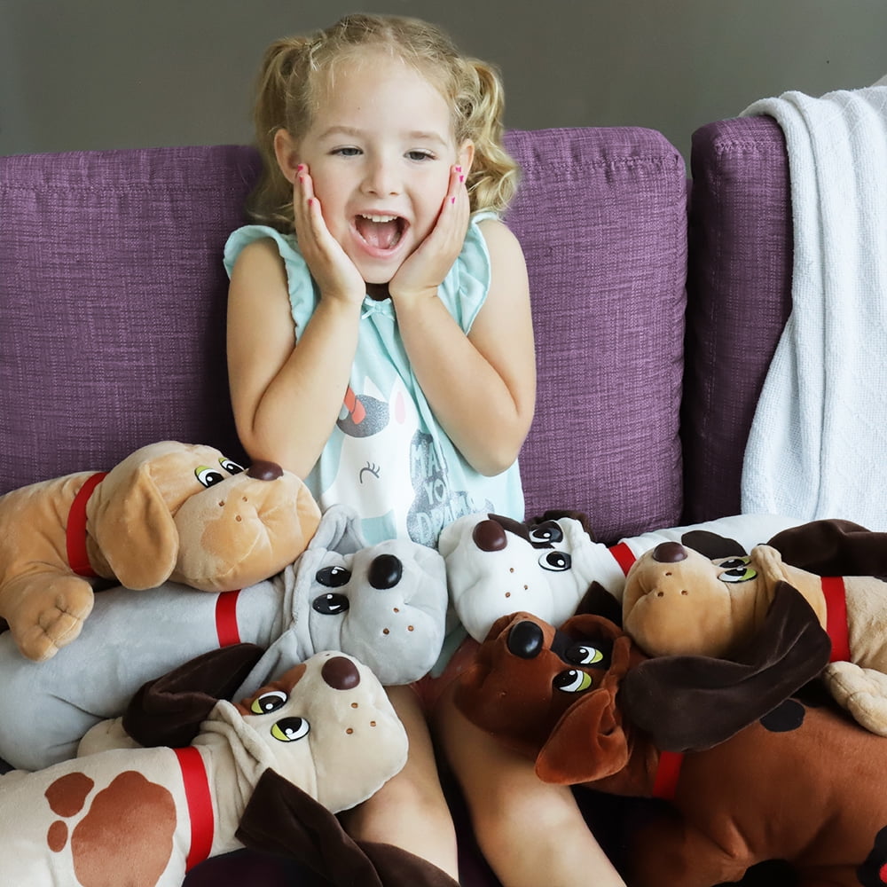 Child on model playing with multiple Pound Puppies plush toys on a purple couch, holding them excitedly with different colored dog plushes featuring red collars