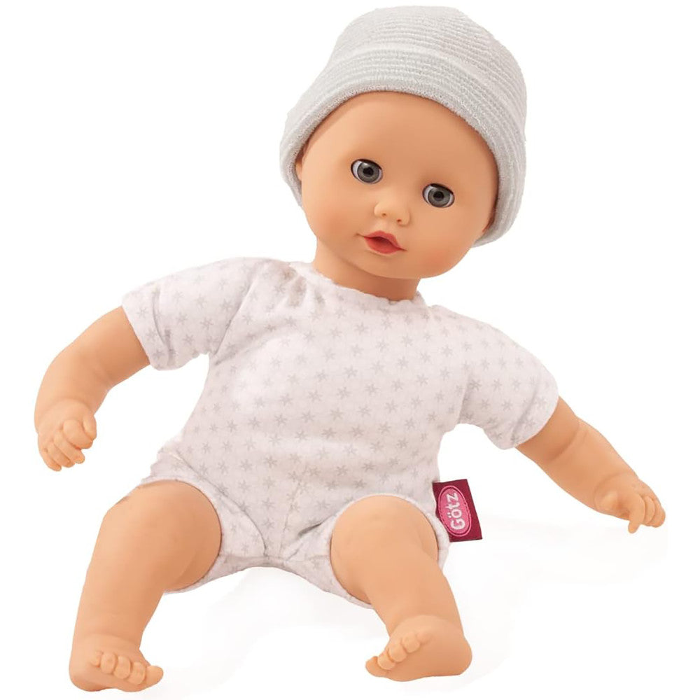 Soft body baby doll wearing grey ribbed cap and white star-print short-sleeve outfit, sitting position on plain white background