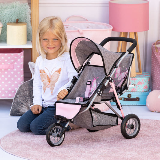 Child on model with gray and pink twin jogging stroller with black handles, modeled by a child in bedroom setting