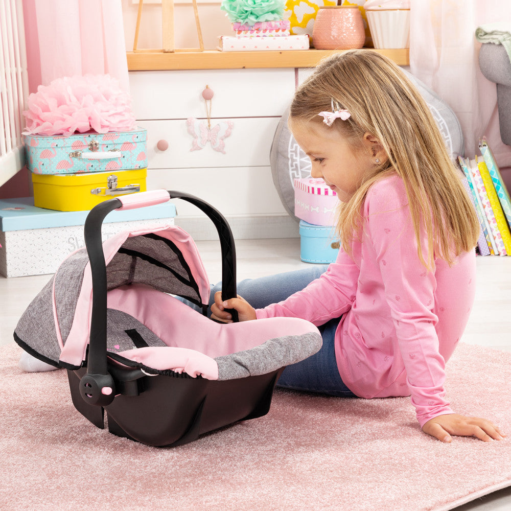 Child on model using doll car seat with black frame and pink and gray fabric, modeled by a child in pink jacket in bedroom setting