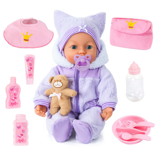 Baby doll with purple and lavender outfit and hat, holding teddy bear, surrounded by accessories including pink bottles, pacifier, bib, bag, and feeding utensil