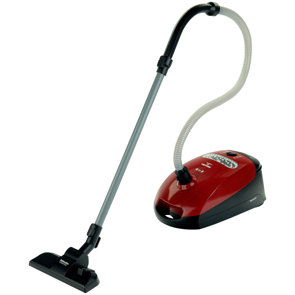 Theo Klein Miele toy vacuum cleaner with red and black canister unit, gray metal handle, and white hose with black nozzle attachment