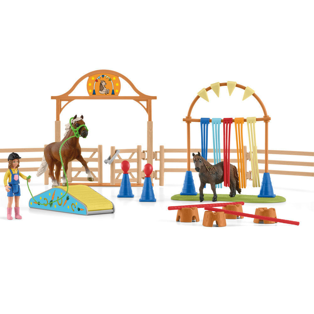Pony agility training playset with wooden barn, two horses, figure, blue and red jumping obstacles, and training cones on plain background